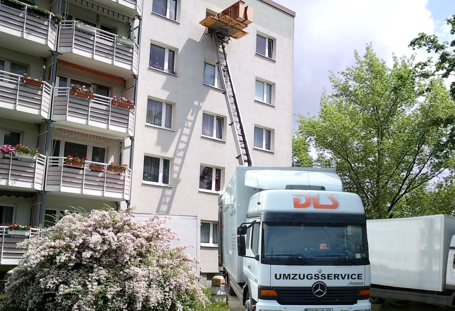DLS-LKW mit Außenlift vor einem Wohnblock