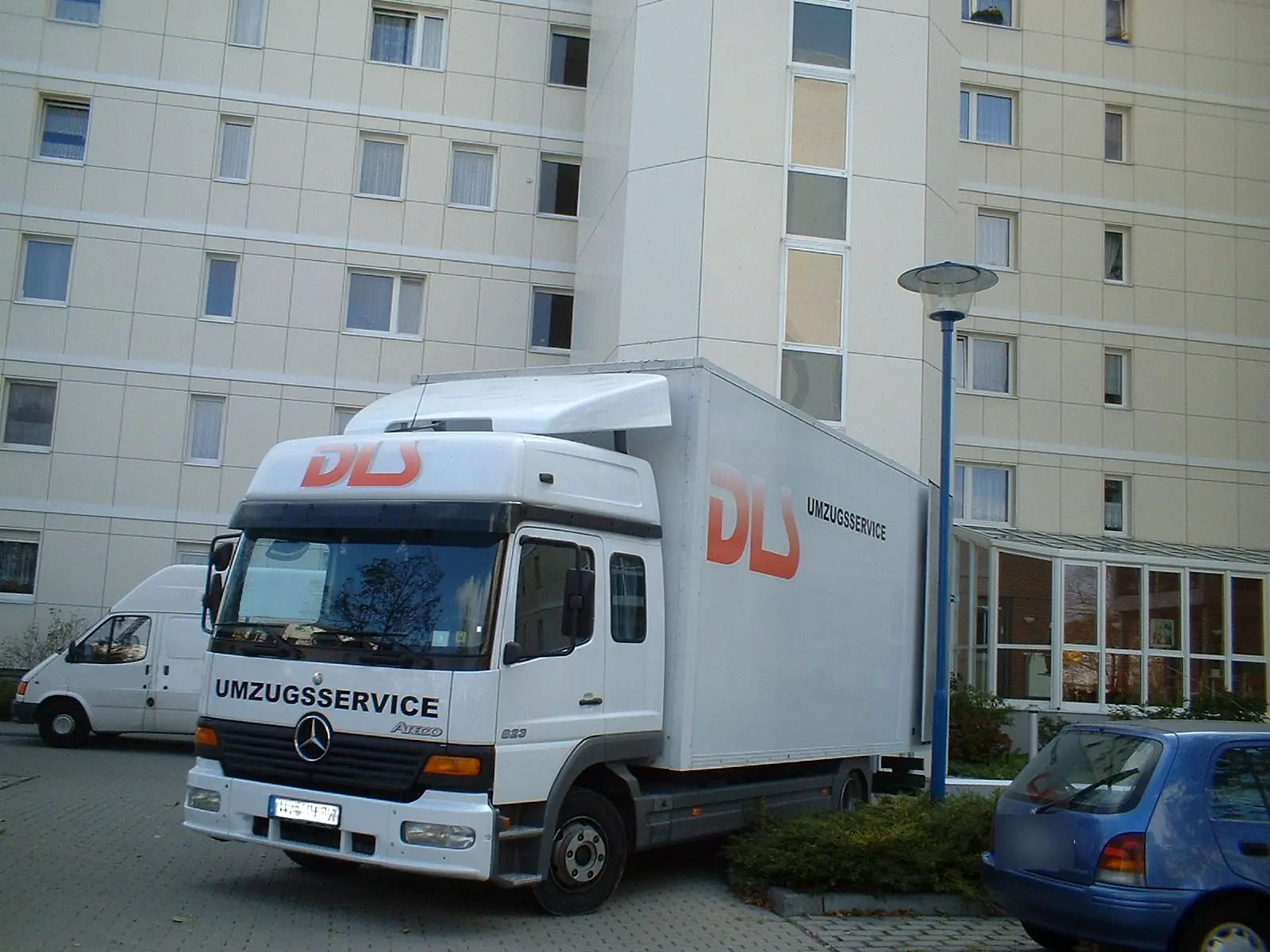 Weißer DLS-Umzugs-LKW vor einem Wohnhaus
